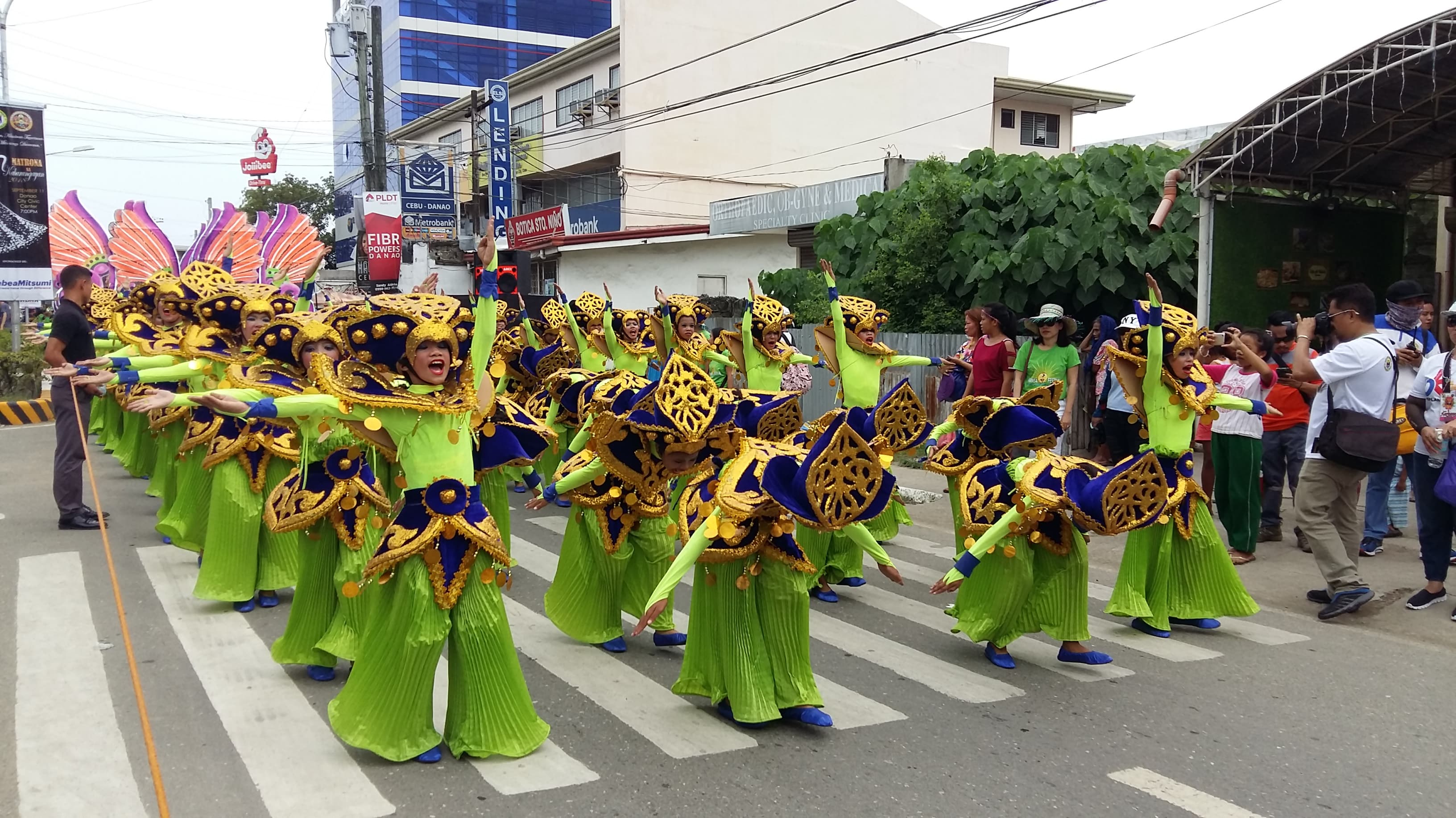 Dancers in red and gold costume filling a Cebu City street during Sinulog